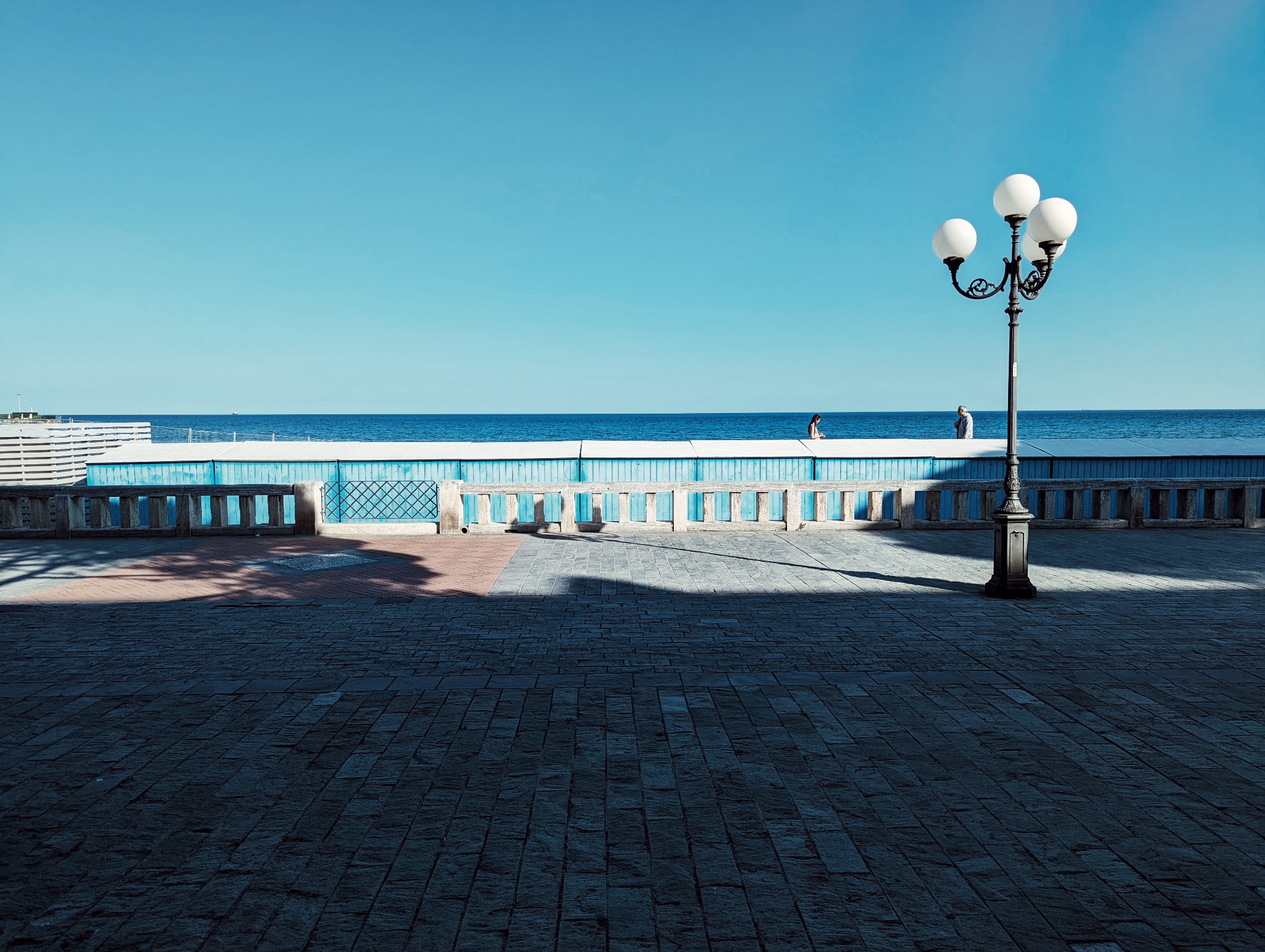 Promenade in Diano Marina with street light in right foreground and the Mediterranean Sea in the background