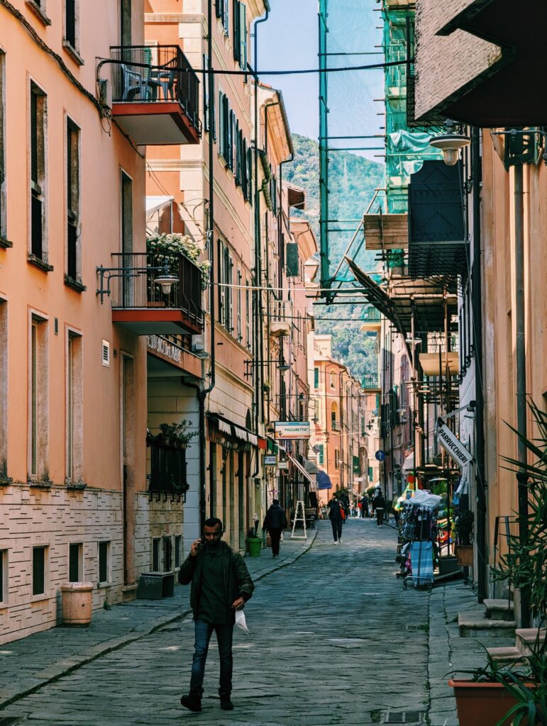 Narrow road in Finale Ligure with a man walking in the foreground