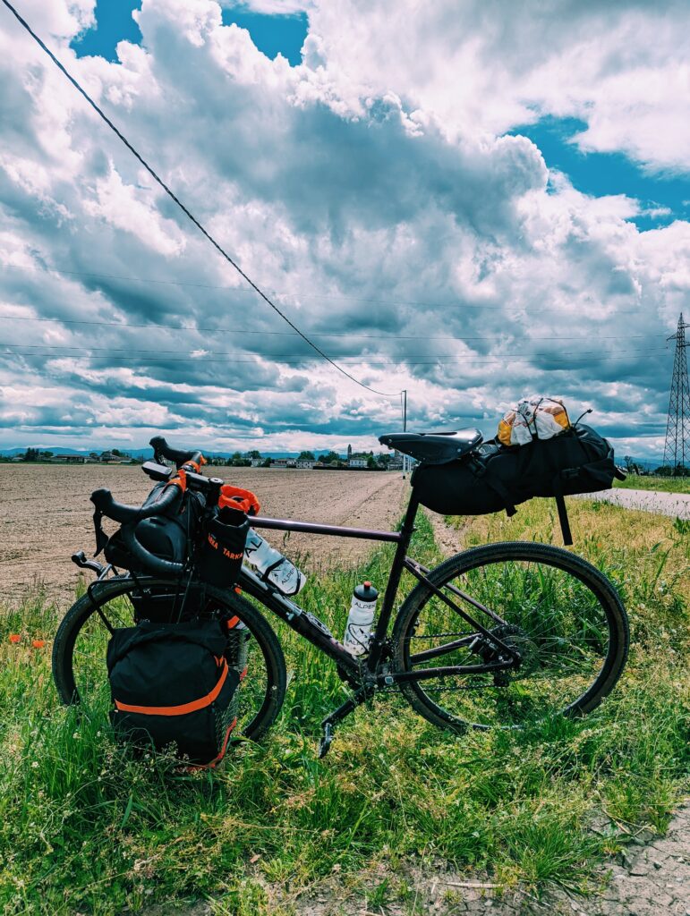 Picture of my loaded touring bike with the Apennins and rain clouds in the background