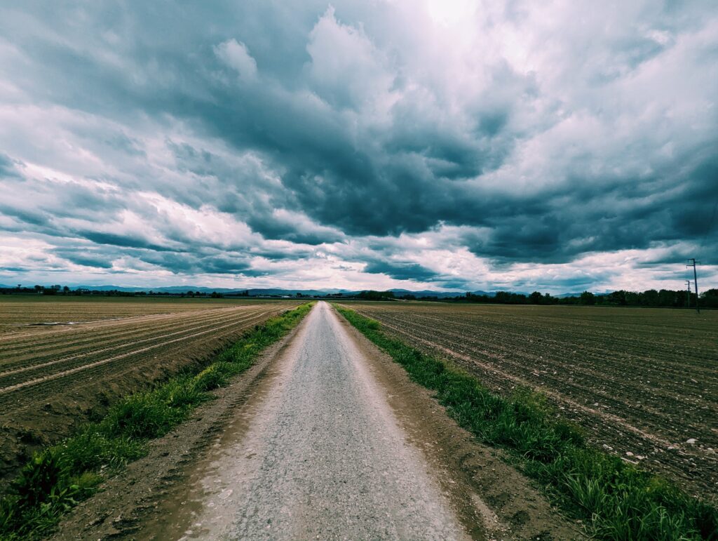 Farm road heading towards the Apennines with threatening rain clouds