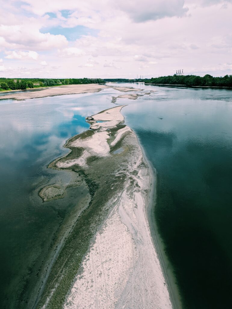 View over Po River from a bridge with abandoned boats on a sandbank