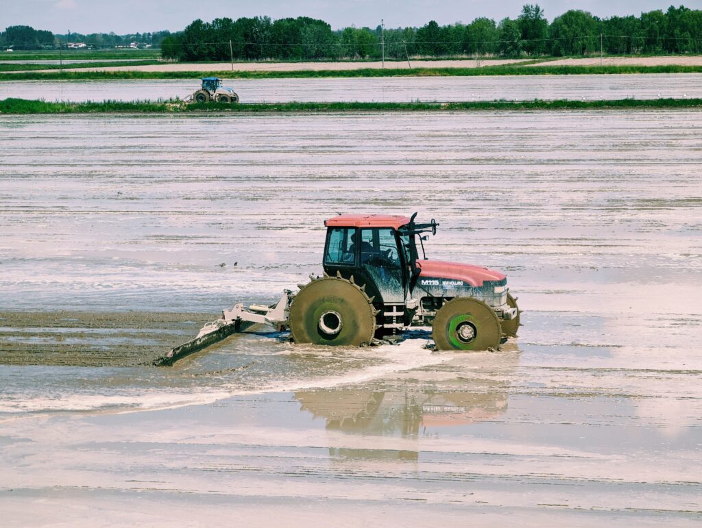 Tractor plowing through wet field