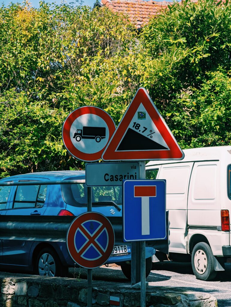 Multiple street signs with cars in the background. One sign indicating a 18.7% decline.