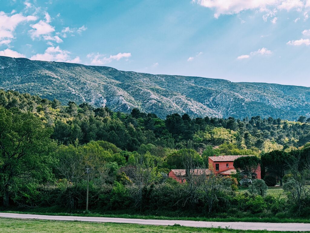 Red house within a sea of green trees in Montagne Sainte-Victoire