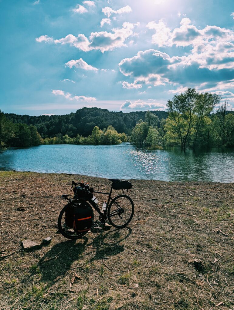 My bike in front of Lac de Bimont with trees growing in the lake