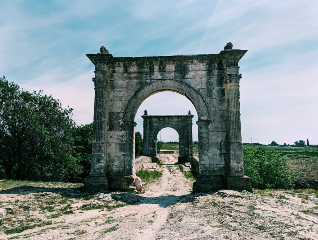 Le Pont Flavien. Roman bridge with a portal on either side. The portal further away is showing through the opening of the nearer.