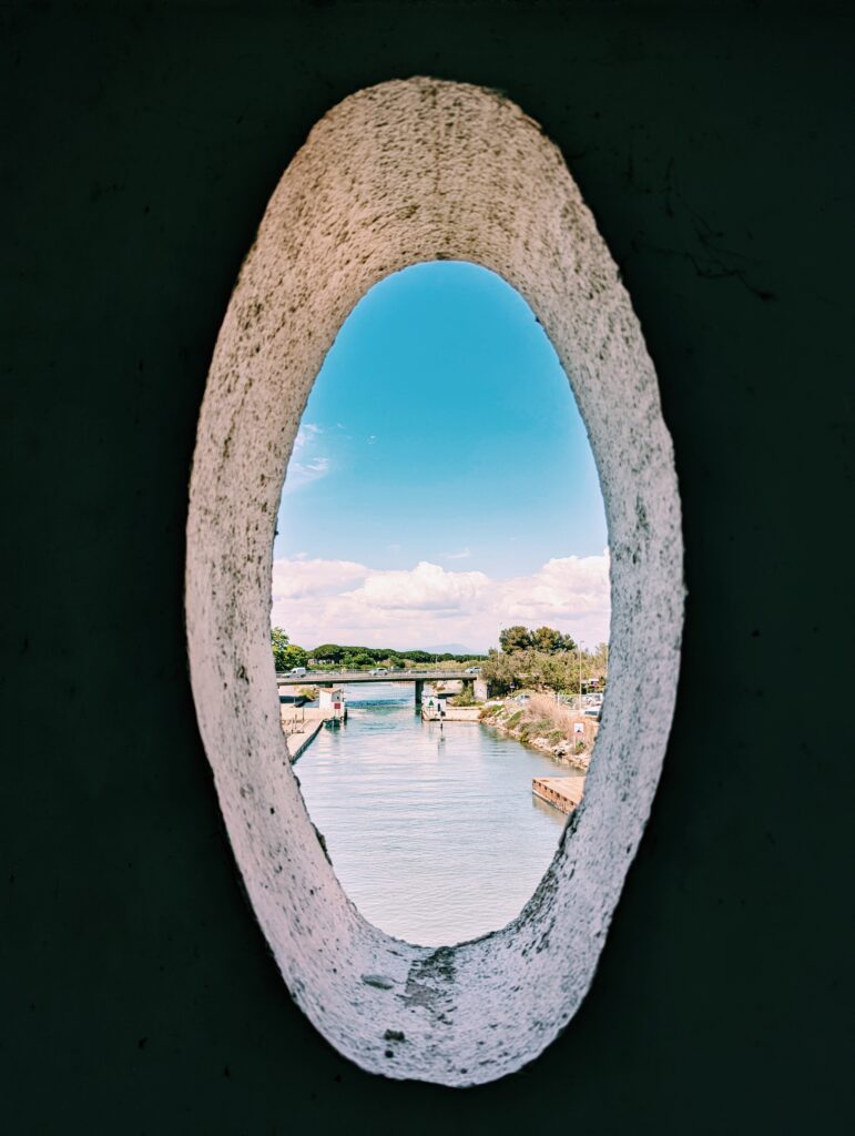 Looking through an oval opening on a bridge in Aigues-Mortes out onto a canal