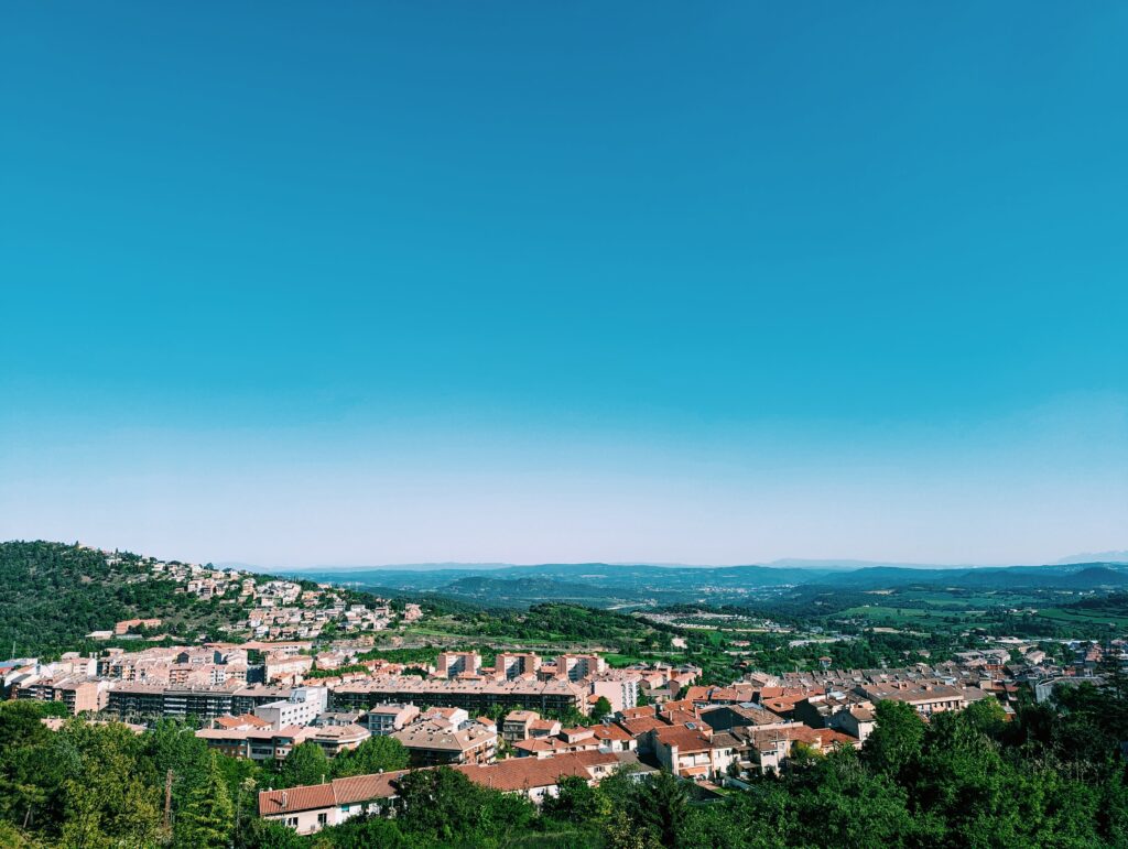 View over Berga with houses in the foreground and vast blue sky taking up more than half of the image