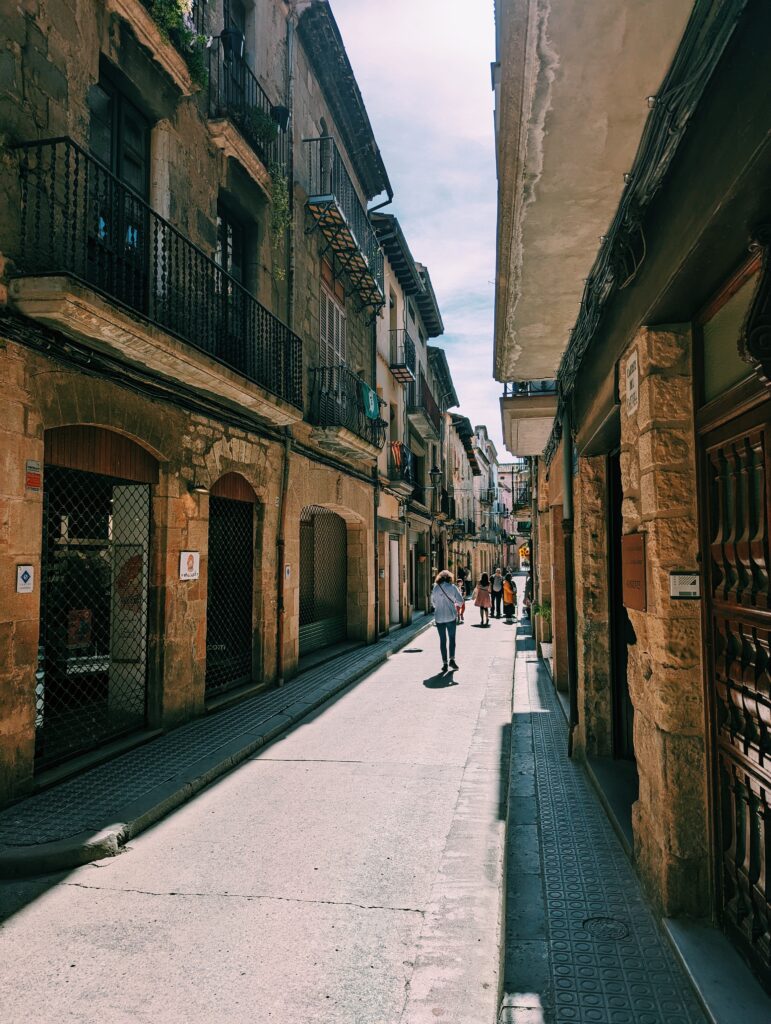 Look down a narrow street in Solsona, a few people walking down the street