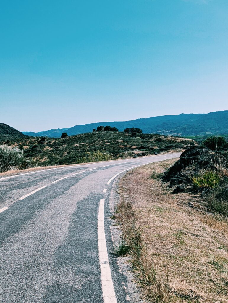A road winding up the hill with hills in the background