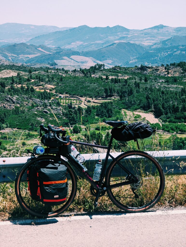 My bike leaned against a guard railing overlooking Terras de Trás-os-Montes vineyards and hills.