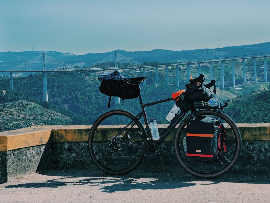 Bike leaned against a low wall with Viaduto do Corgo in Vila Real in the background