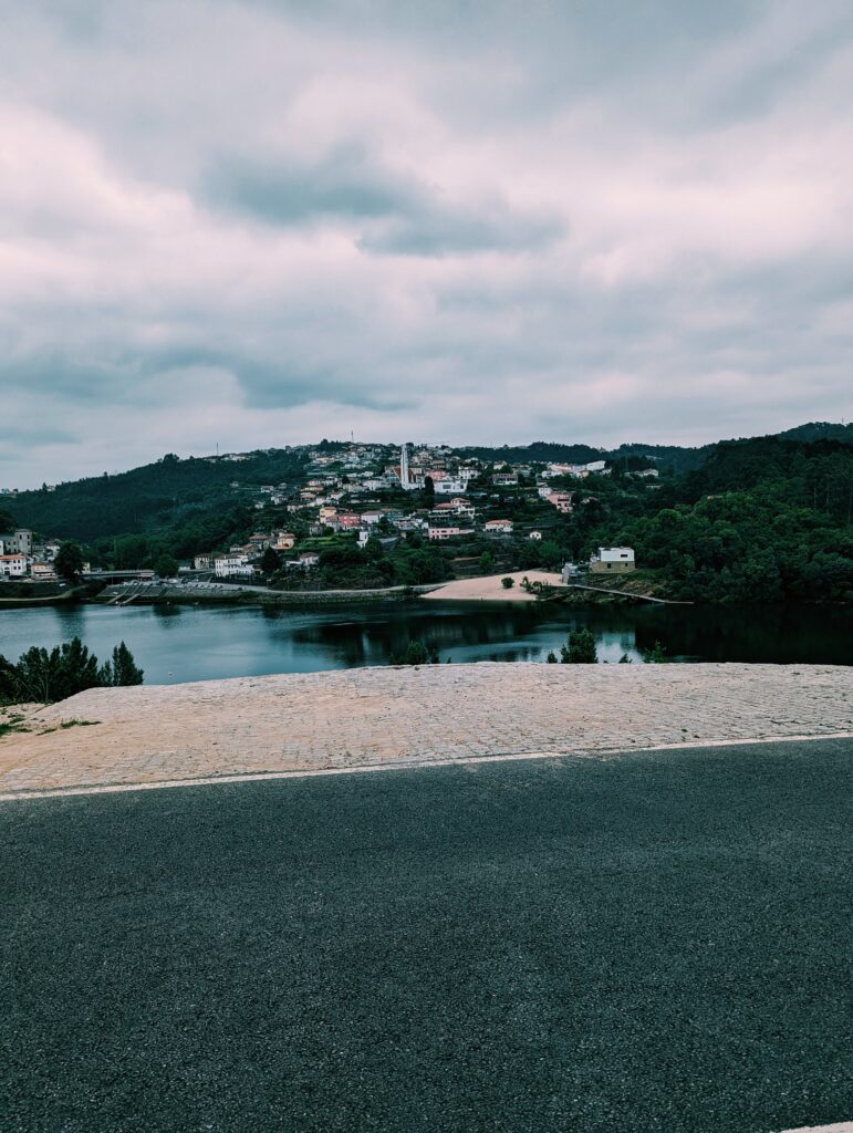 View of a village across the Douro River. Prominent modern church and houses going up the hill.