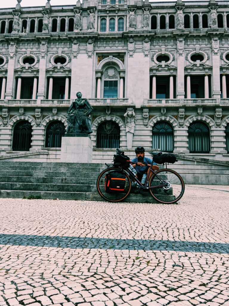 Me sitting behind my bike on the steps in front of the town hall in Porto.